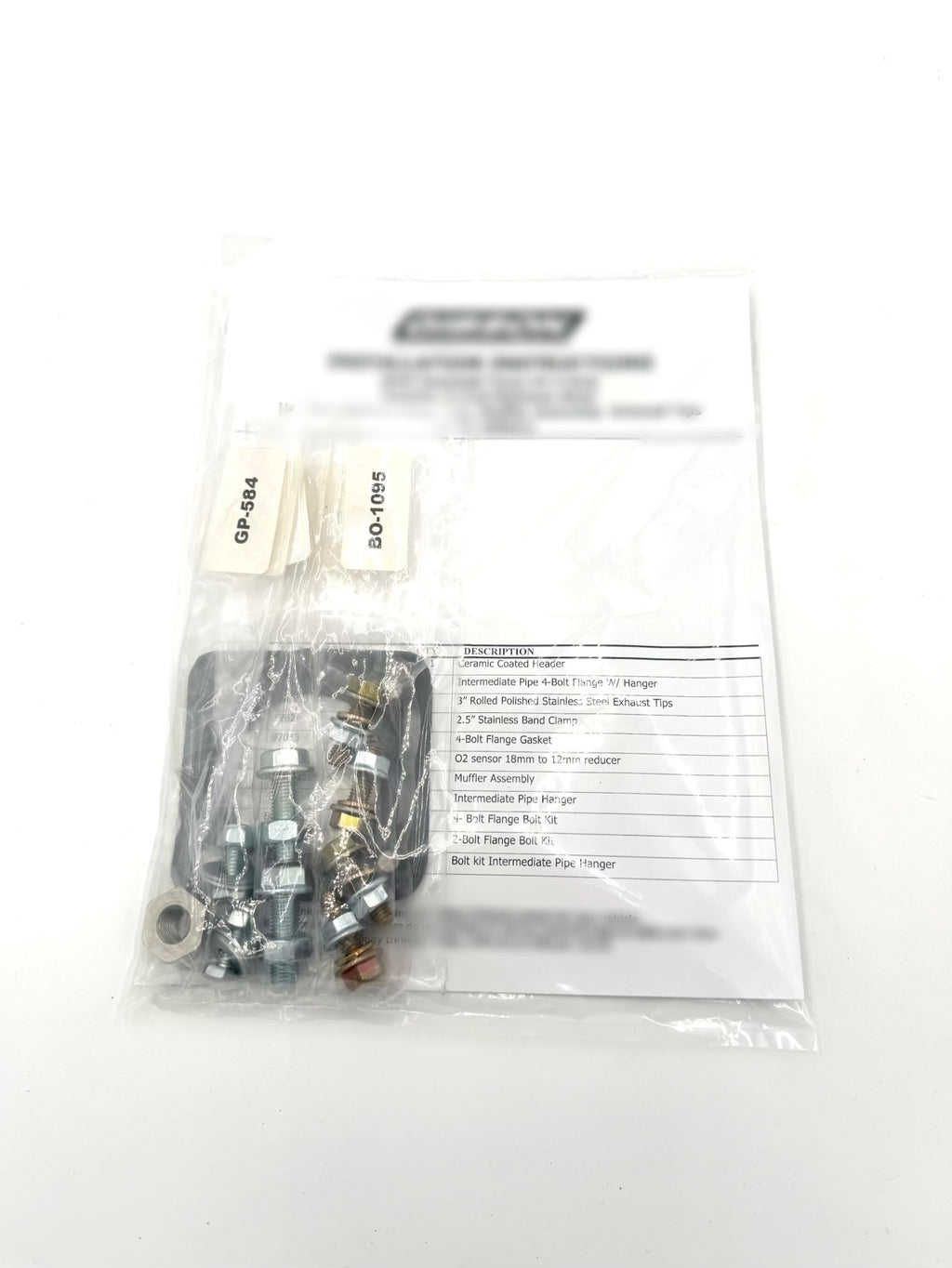 Hardware and components included in the Kawasaki TERYX4 H2 exhaust installation kit, showing bolts, clamps, and fittings provided with Fast UTV’s full exhaust upgrade.