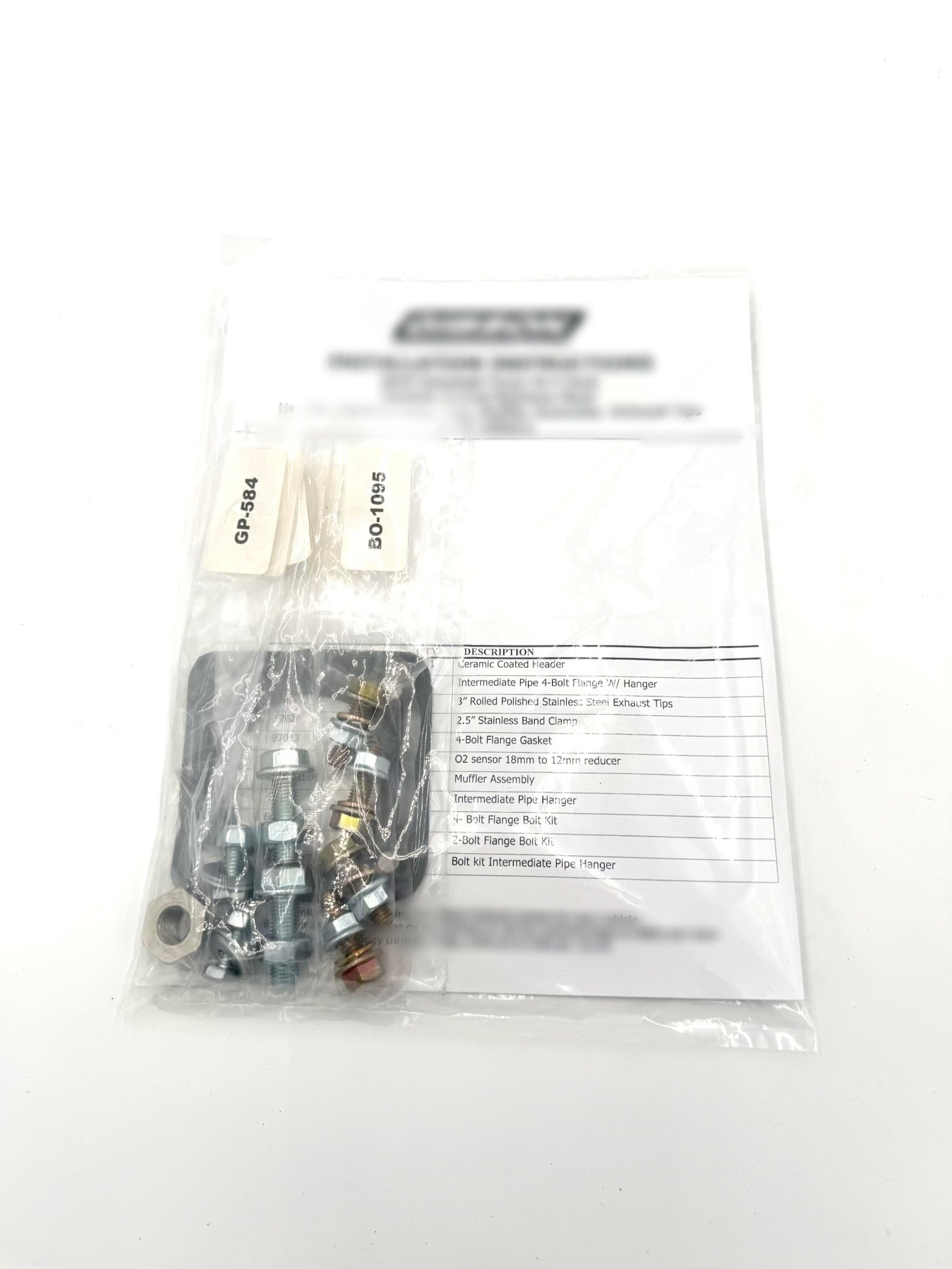 Hardware and components included in the Kawasaki TERYX4 H2 exhaust installation kit, showing bolts, clamps, and fittings provided with Fast UTV’s full exhaust upgrade.